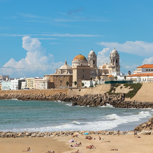a beach with buildings and a body of water in the background
