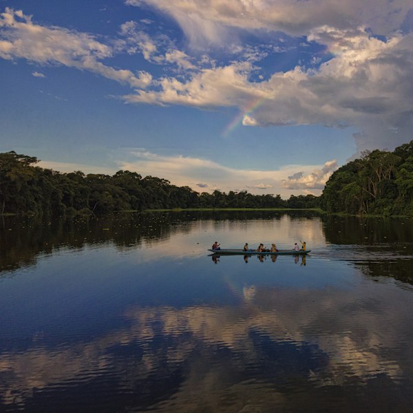 body of water near green trees under blue sky and white clouds during daytime