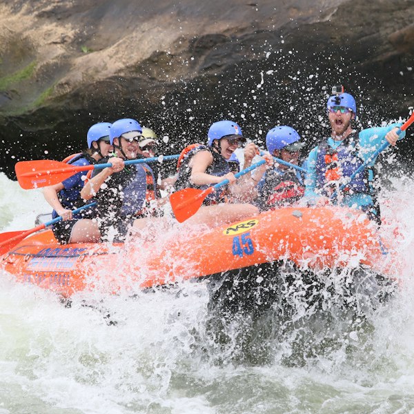 people riding orange kayak on water during daytime