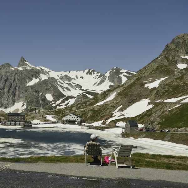 a man sitting on a bench in front of a mountain