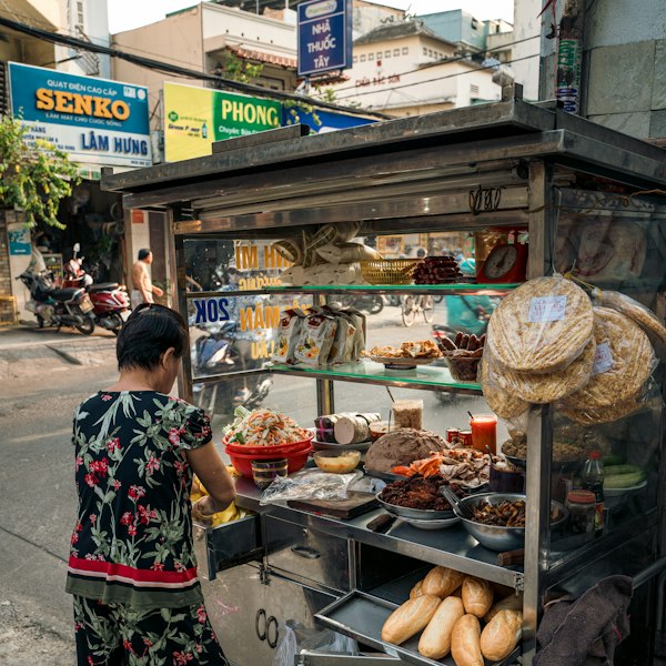 a woman standing in front of a food cart