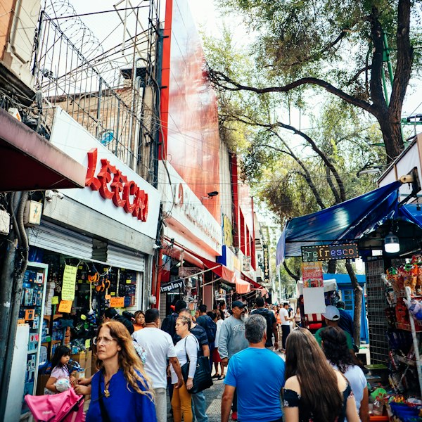 a group of people walking down a street next to stores