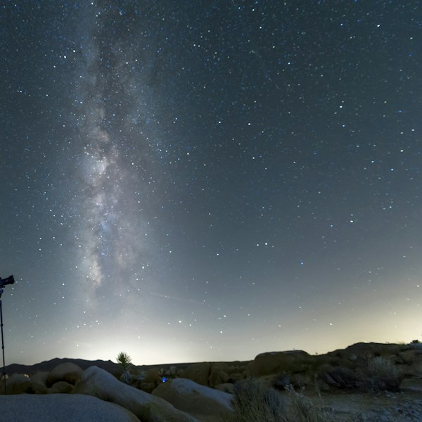 black tripod on snow covered ground under starry night
